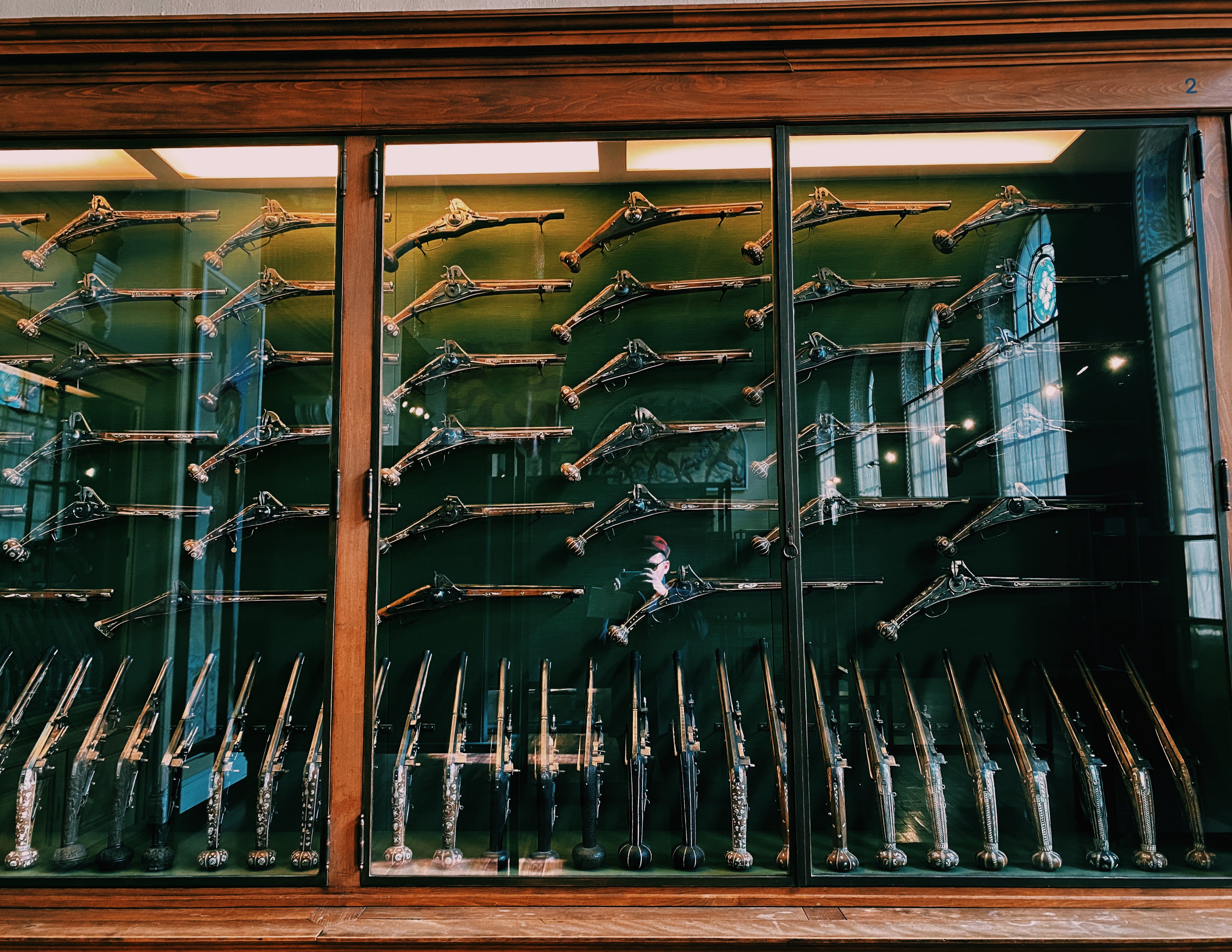 Antique firearms display cabinet at Musée d'Art et d'Histoire Geneva — flintlock pistols and muskets