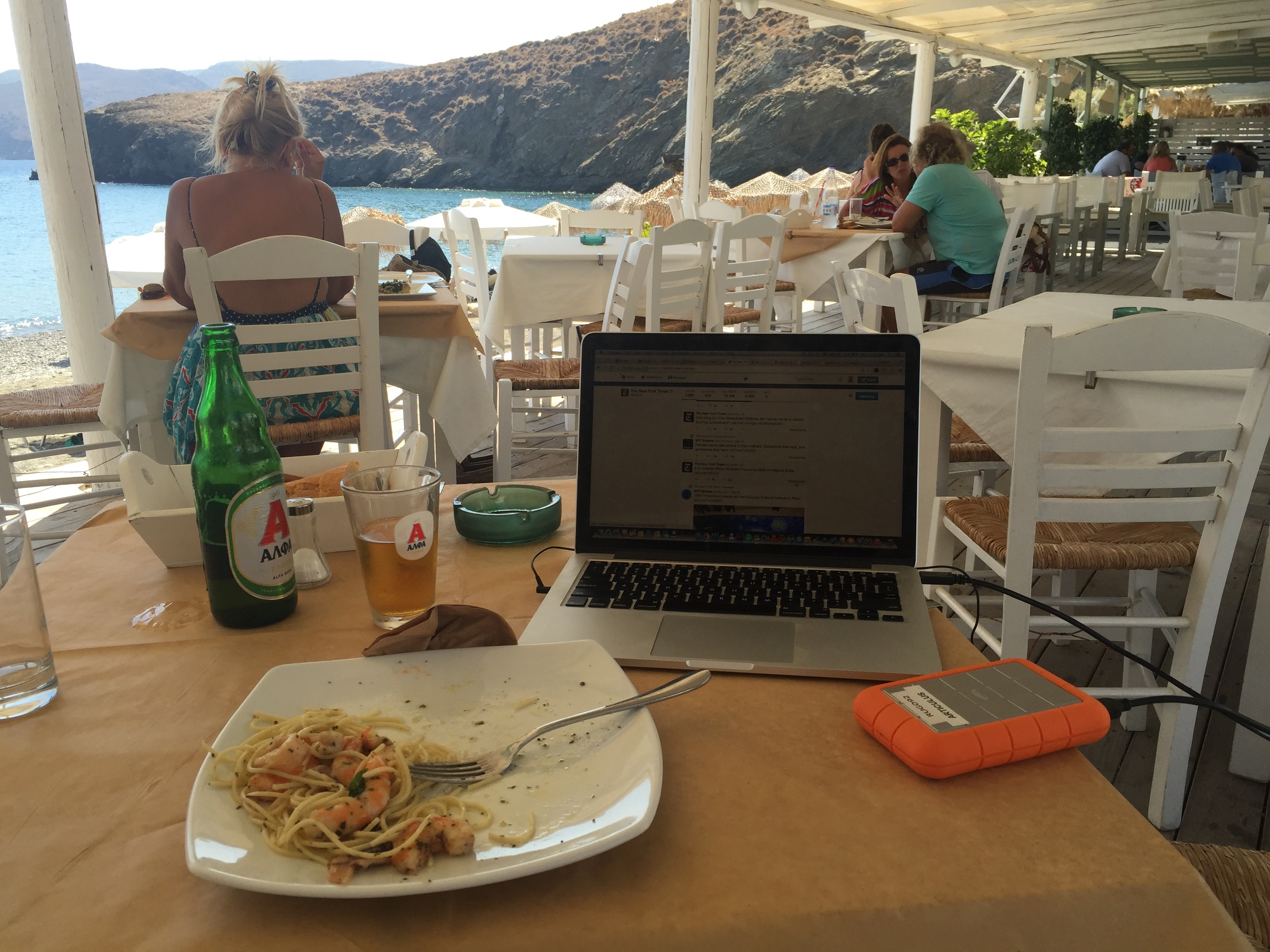 Working remotely at a beach taverna in Astypalea, pasta, Alpha beer, laptop