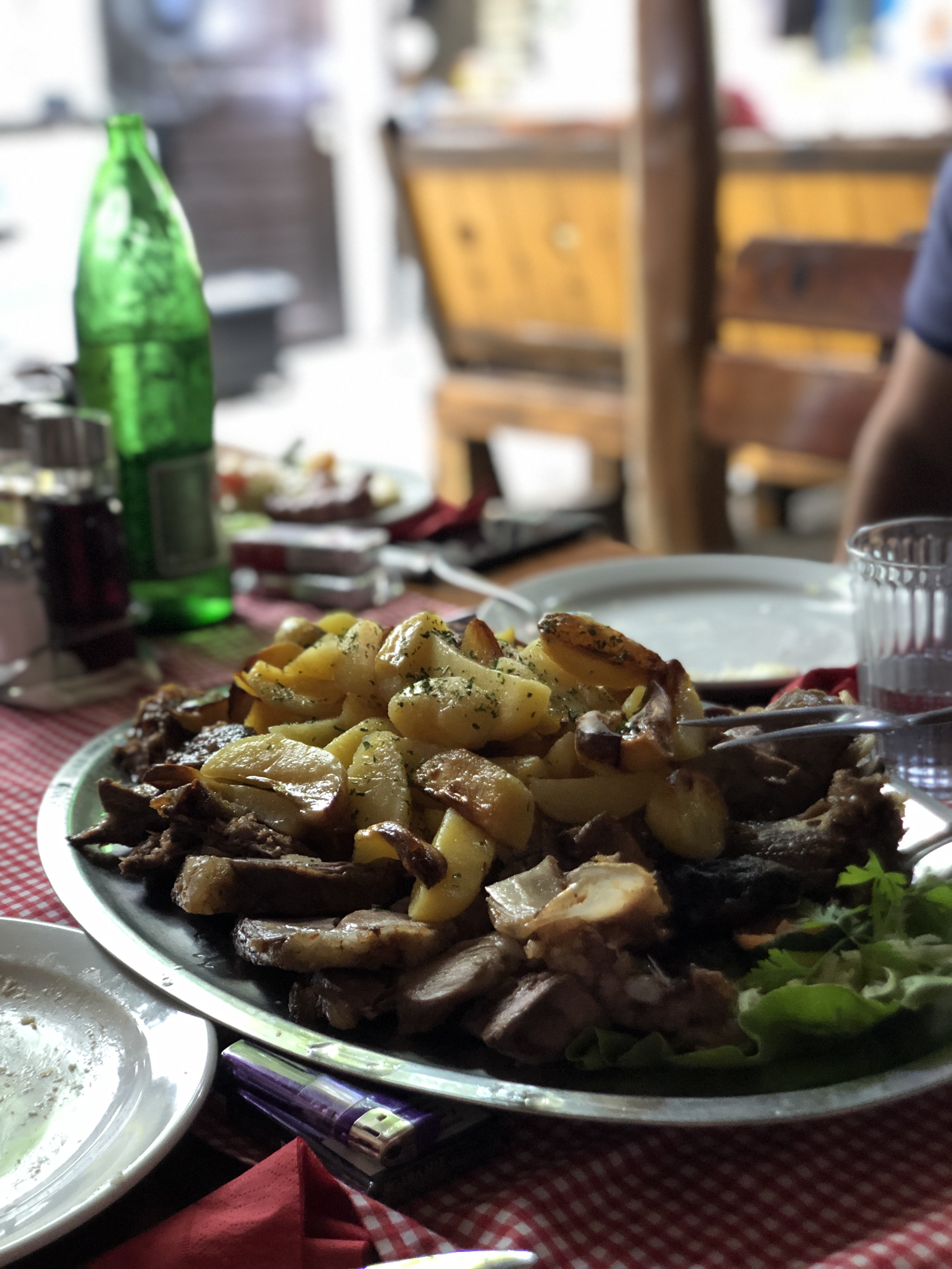 Giant meat platter with roasted potatoes on a silver plate at Bates, Subotica