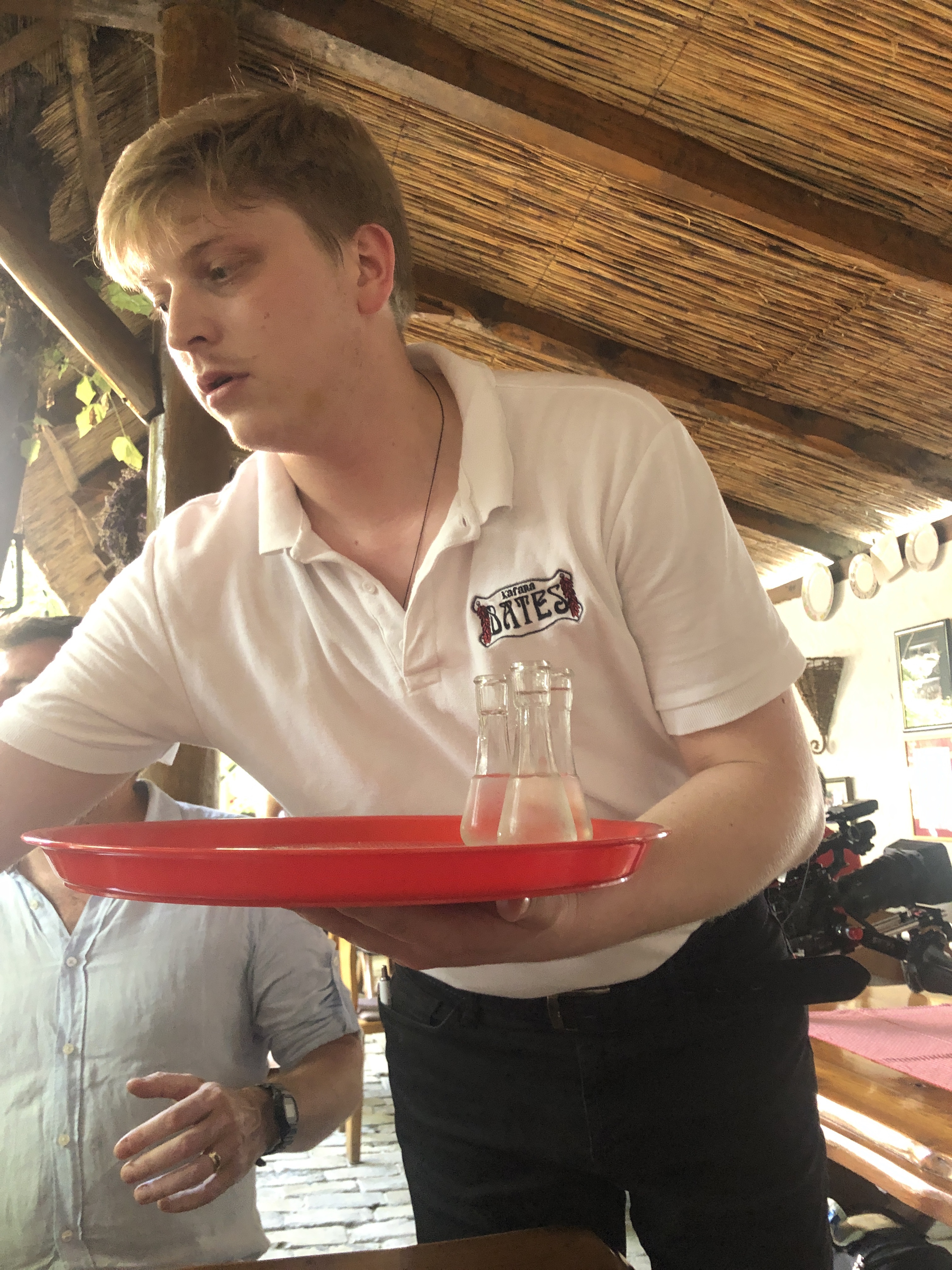 The waiter arriving with a tray of rakia at Bates, Subotica