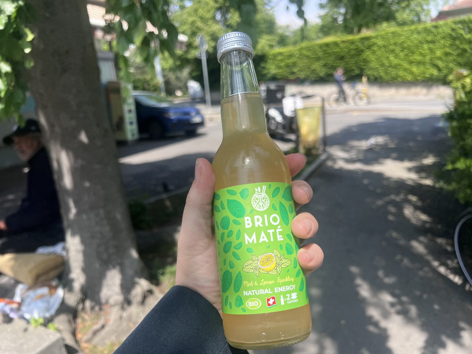 Brio Maté bottle held up on a Geneva street