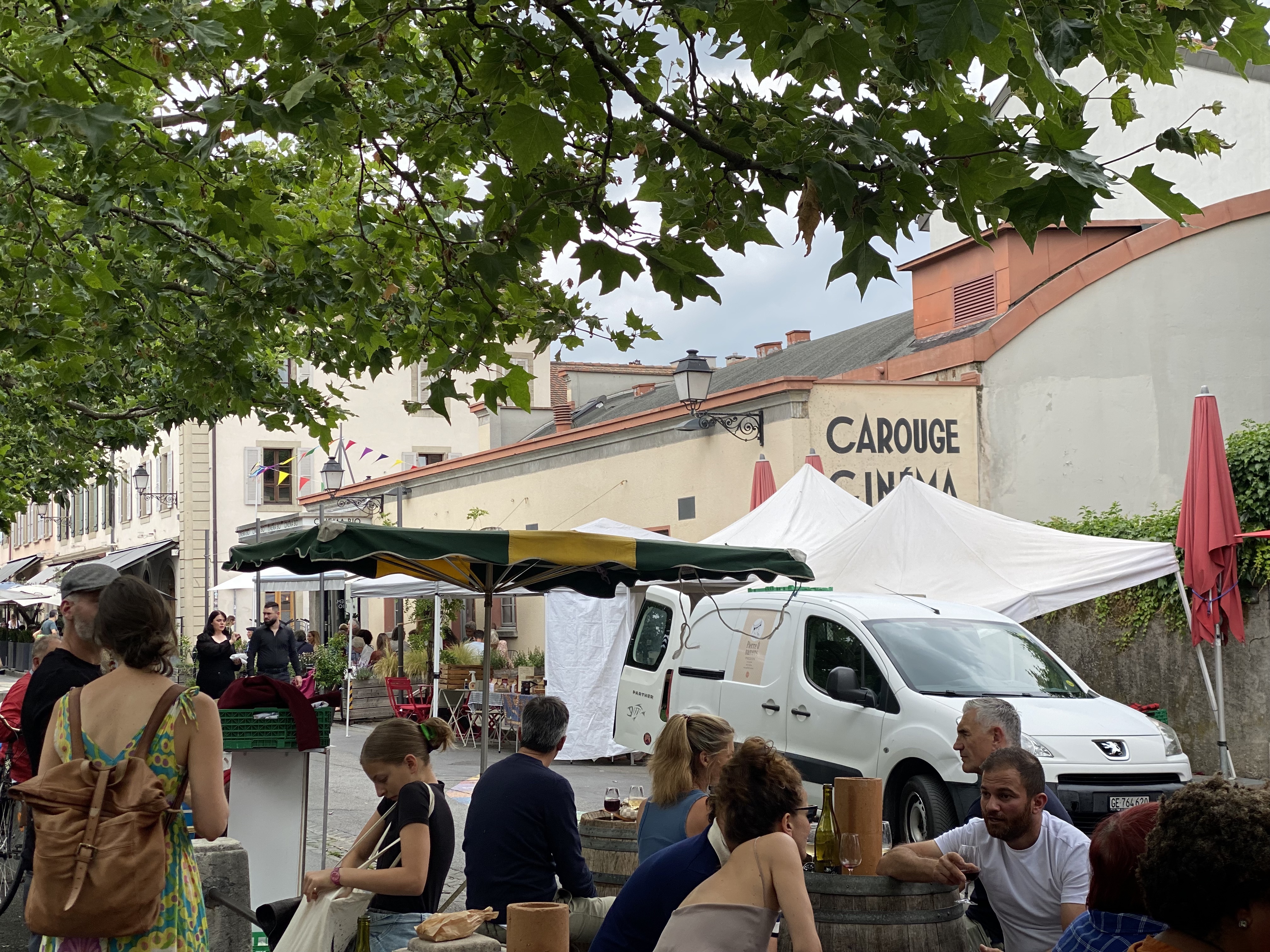 Saturday market at Carouge — violinist playing in the square, Carouge Cinéma in the background