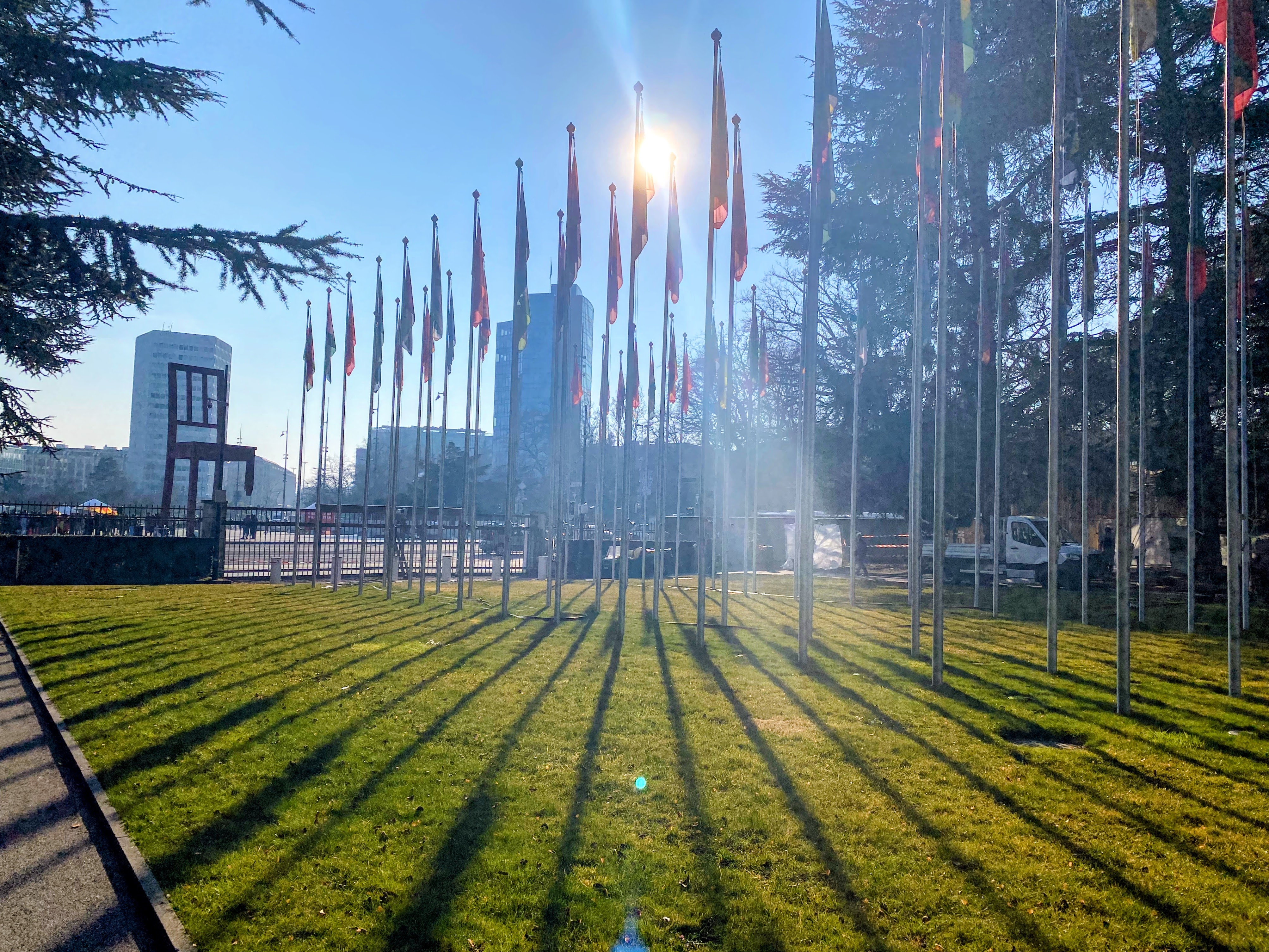 Flag plaza outside the UN in Geneva at golden hour, looking towards the Broken Chair