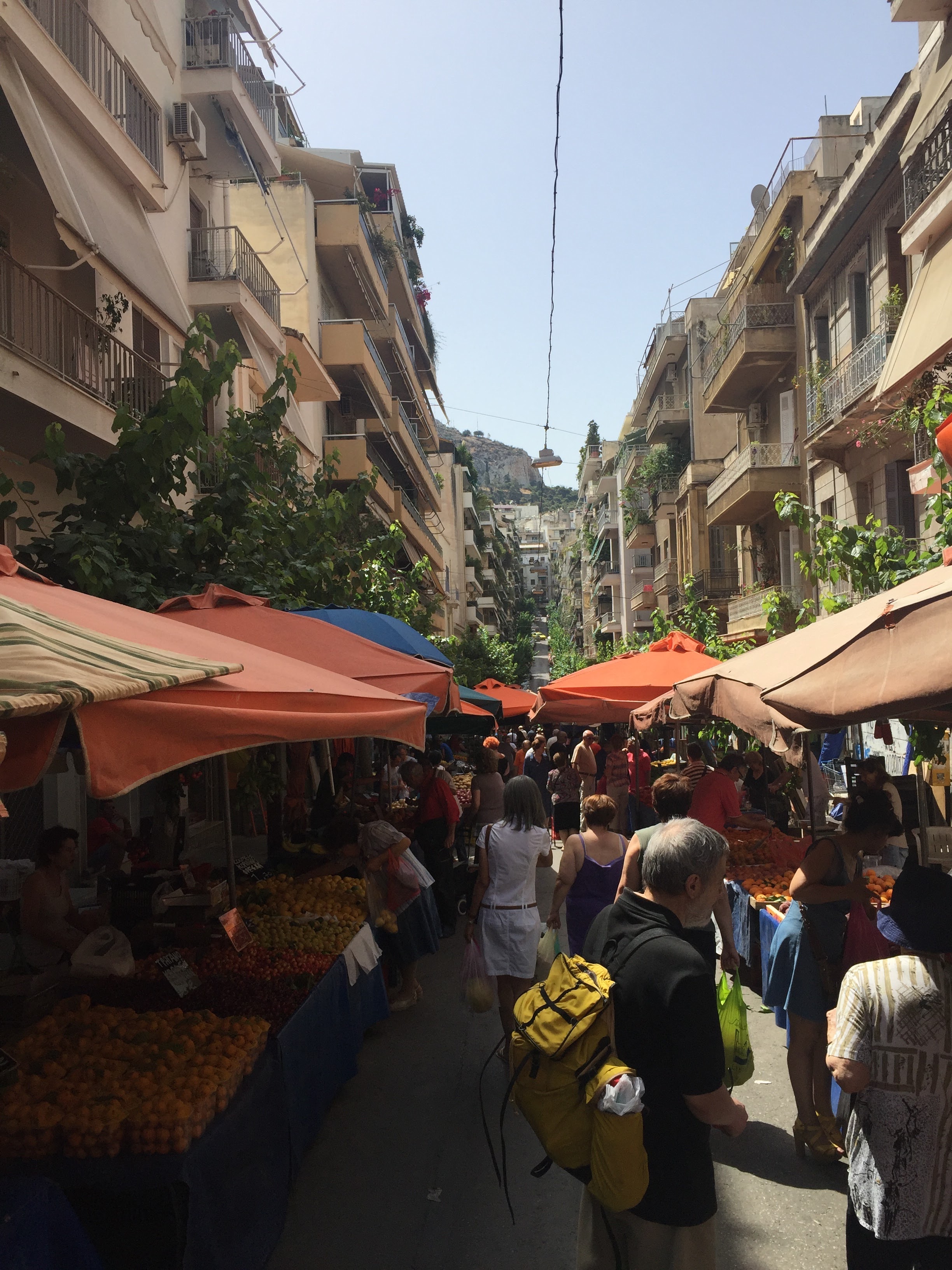 Exarchia Saturday market Athens — produce stalls, crowds, apartment buildings