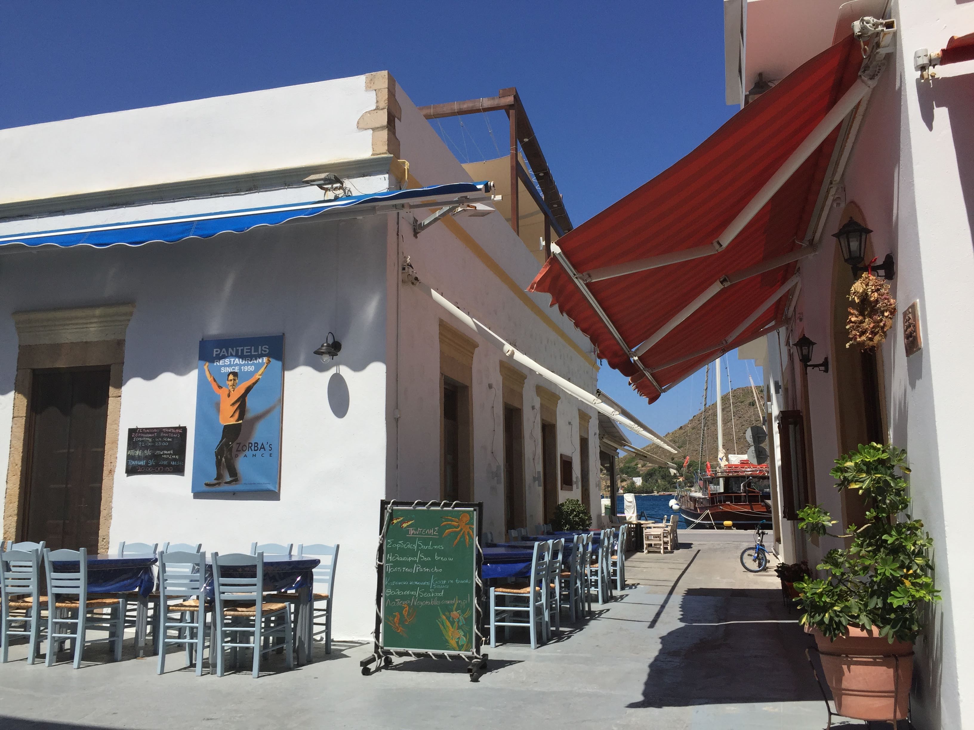 Pantelis, a taverna in Patmos open since 1950, with blue-painted chairs and red awnings