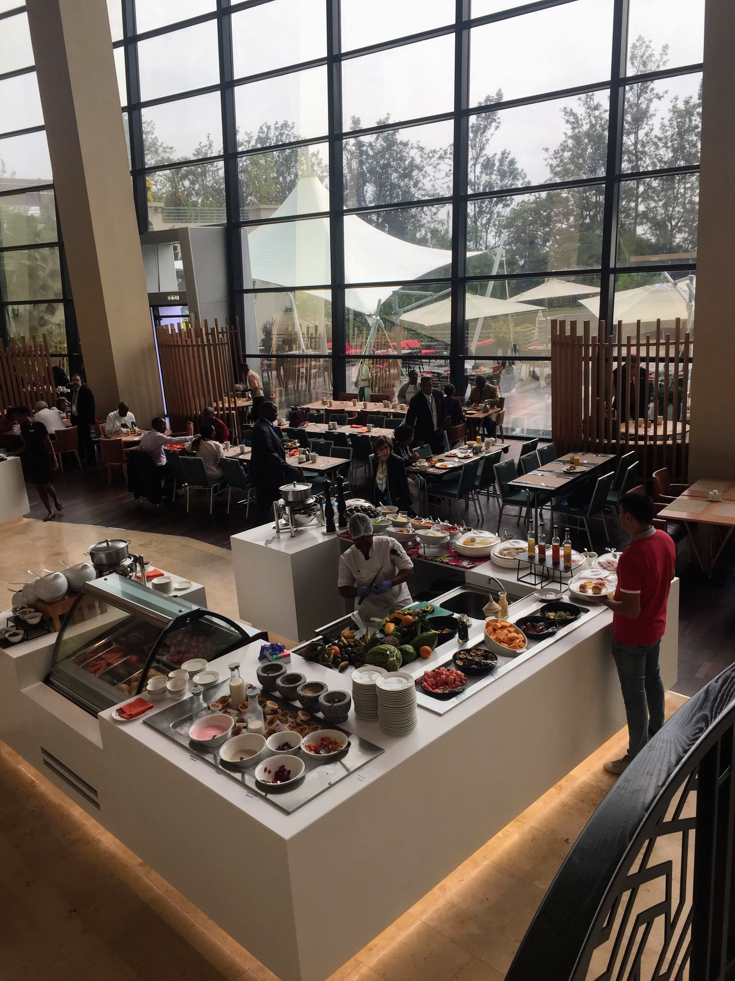 Kigali Marriott breakfast buffet — fresh produce spread, floor-to-ceiling windows, morning