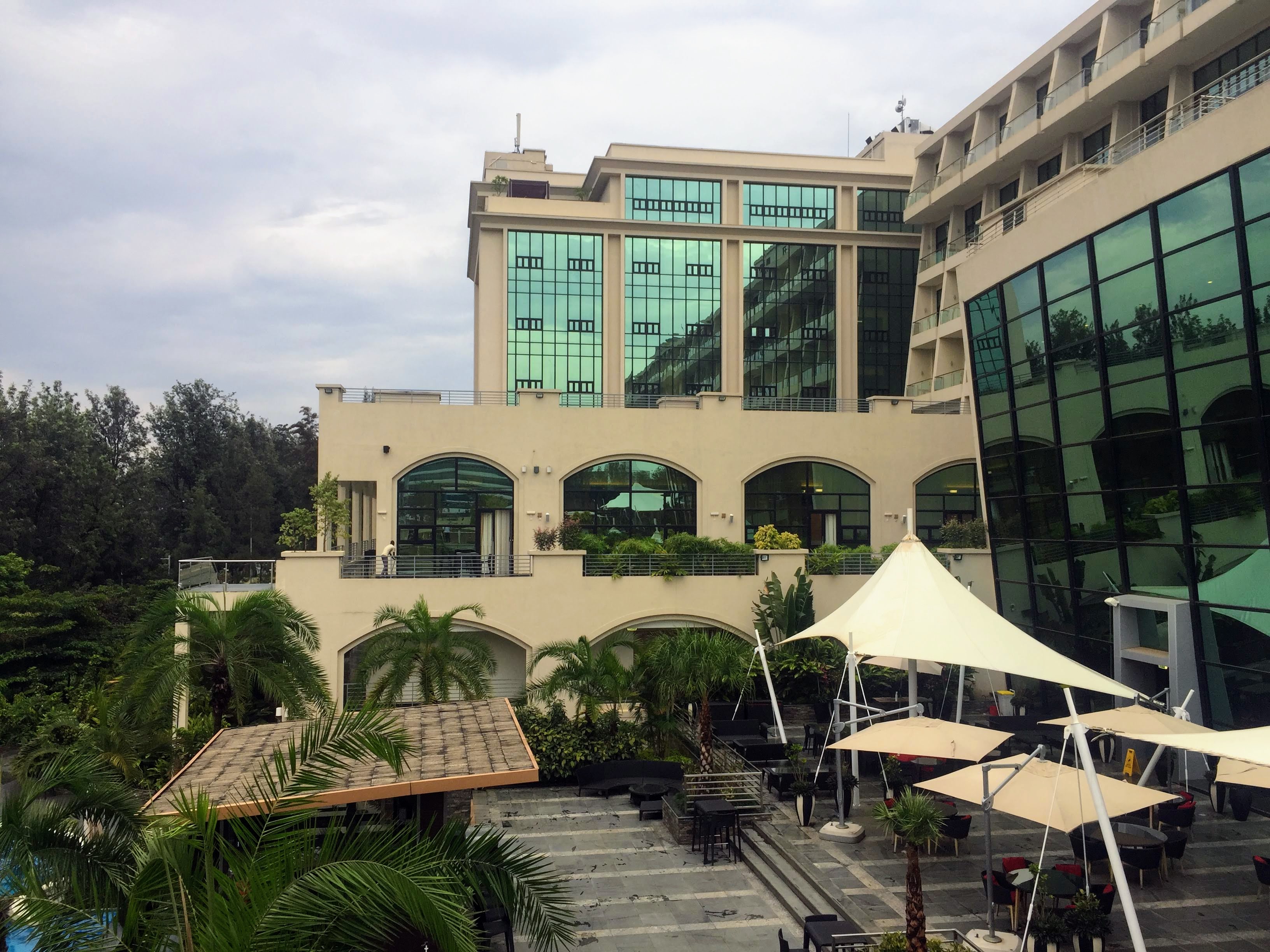 Kigali Marriott exterior at dusk — curved turquoise glass facade