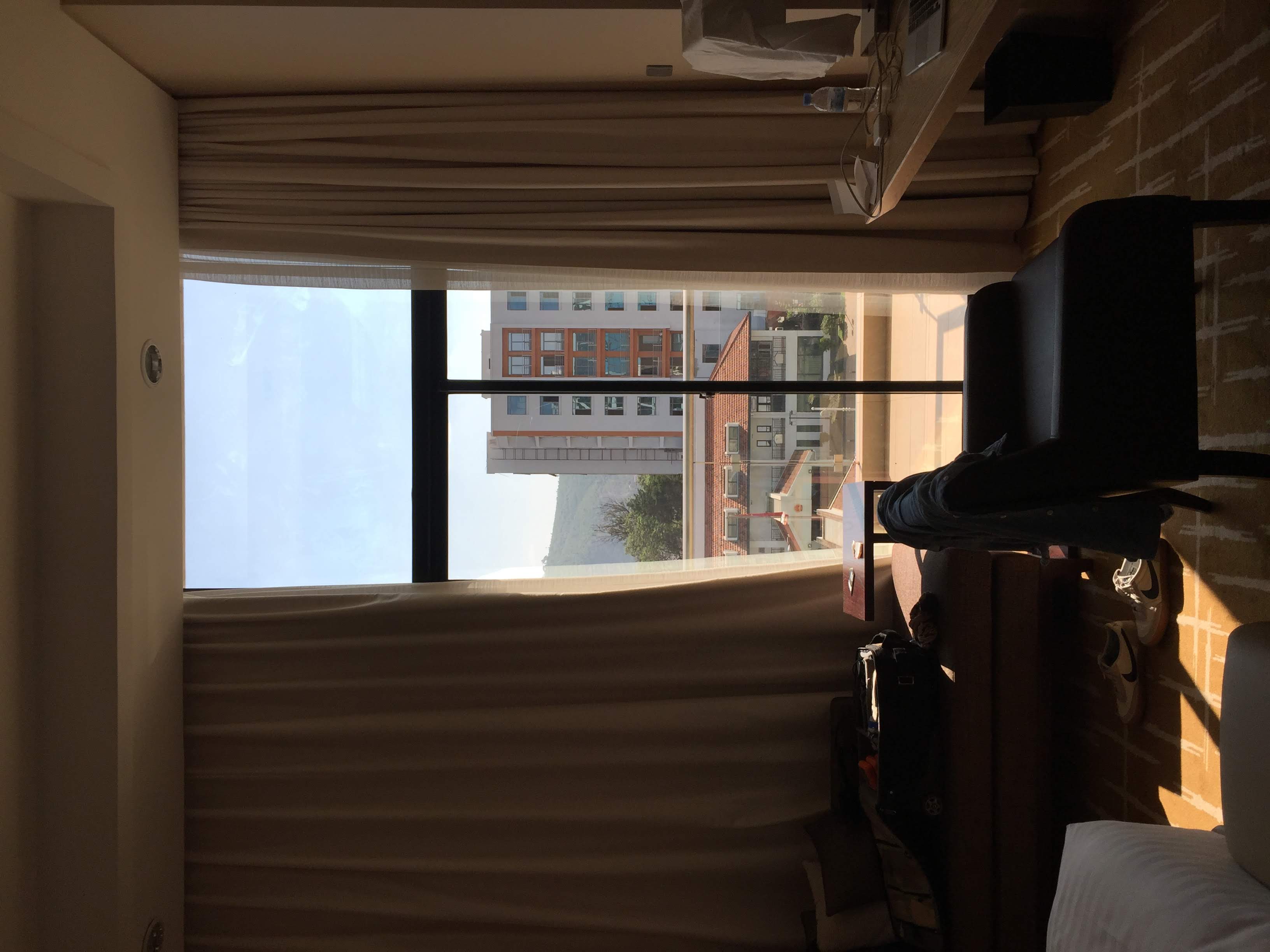 Kigali Marriott room — afternoon light, Kigali hills in the background through the window