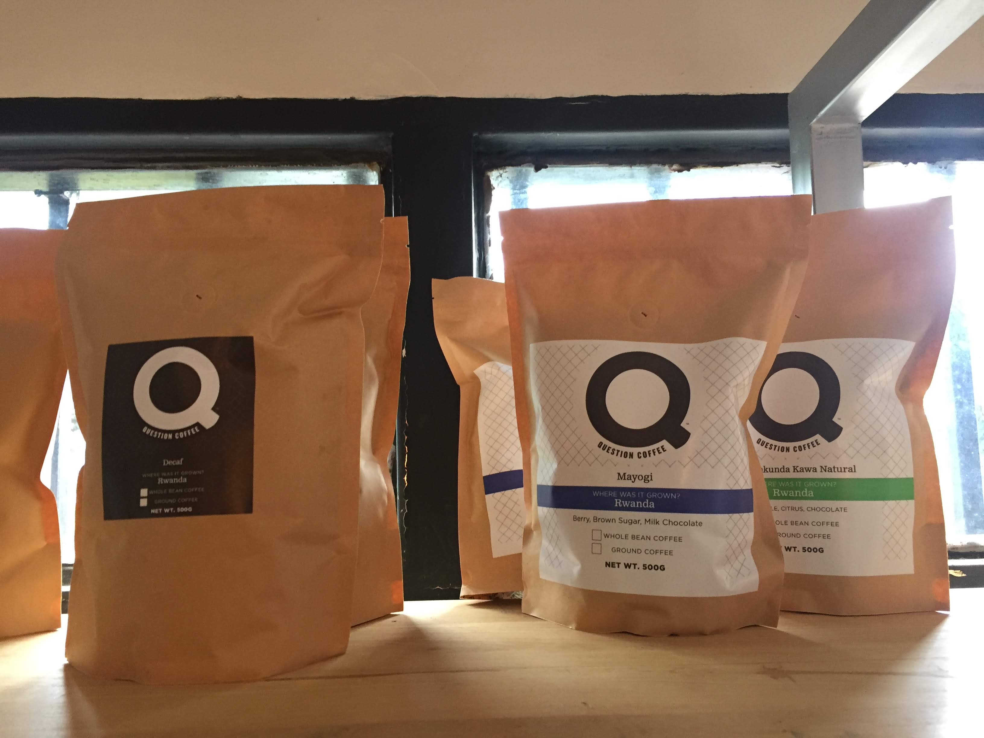 Question Coffee bags — Mayogi, Rukunda Kawa Natural, Decaf Rwanda — lined up in window light