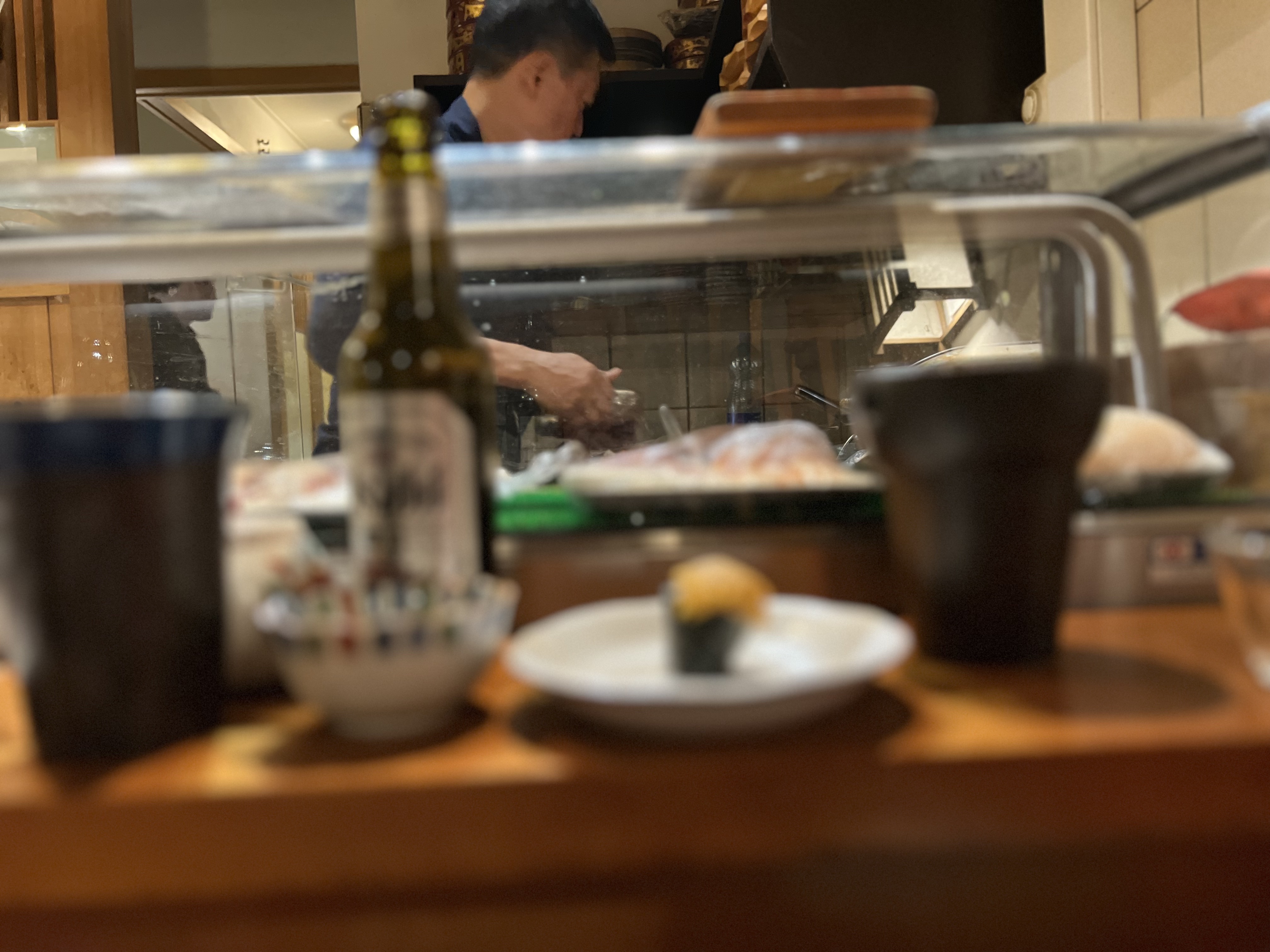The chef working at Nagomi — seen through the glass