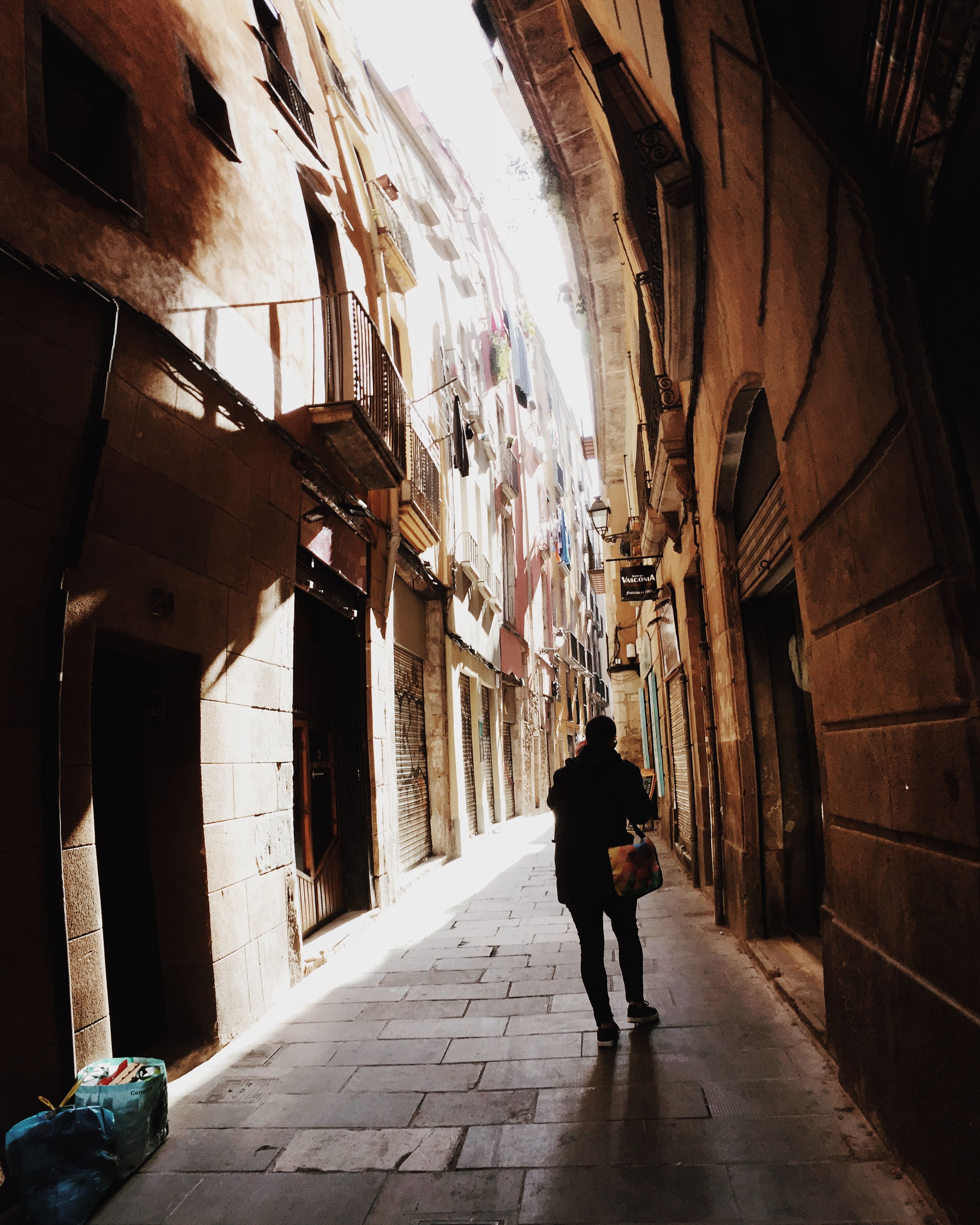 Gothic Quarter alley, Barcelona, panorama distortion, figure walking toward light