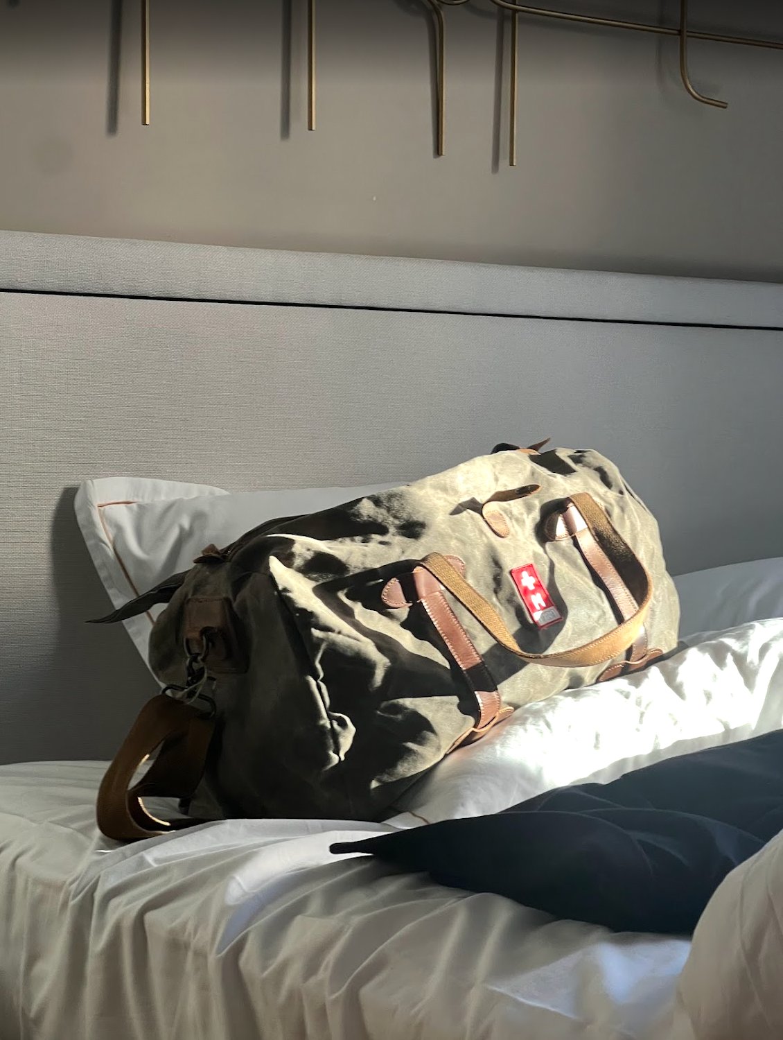 Travel bag on hotel bed, morning light