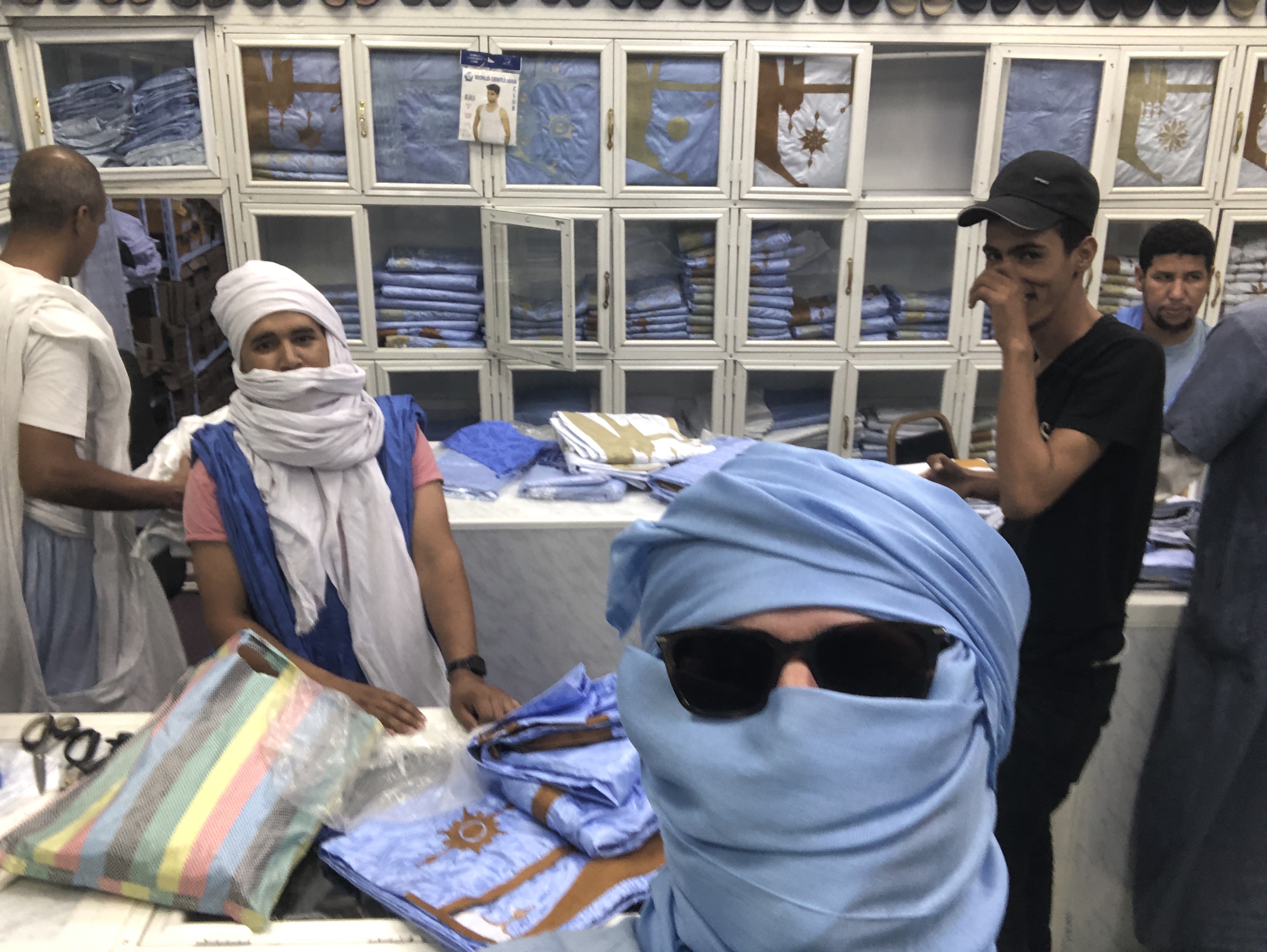 Trying on a traditional blue Mauritanian headwrap in the market in Nouakchott