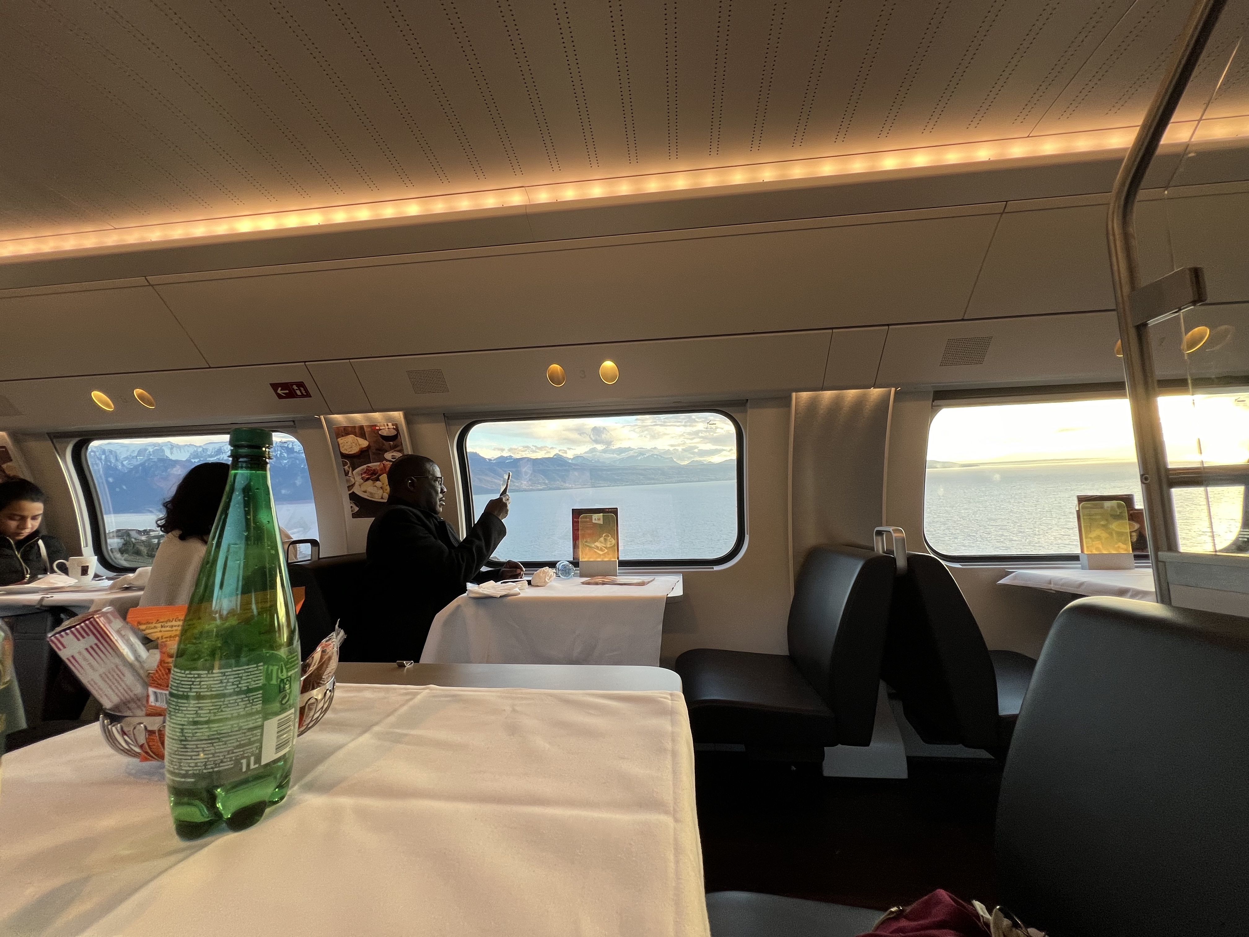 Swiss train restaurant car — white tablecloth tables, Alps through the window