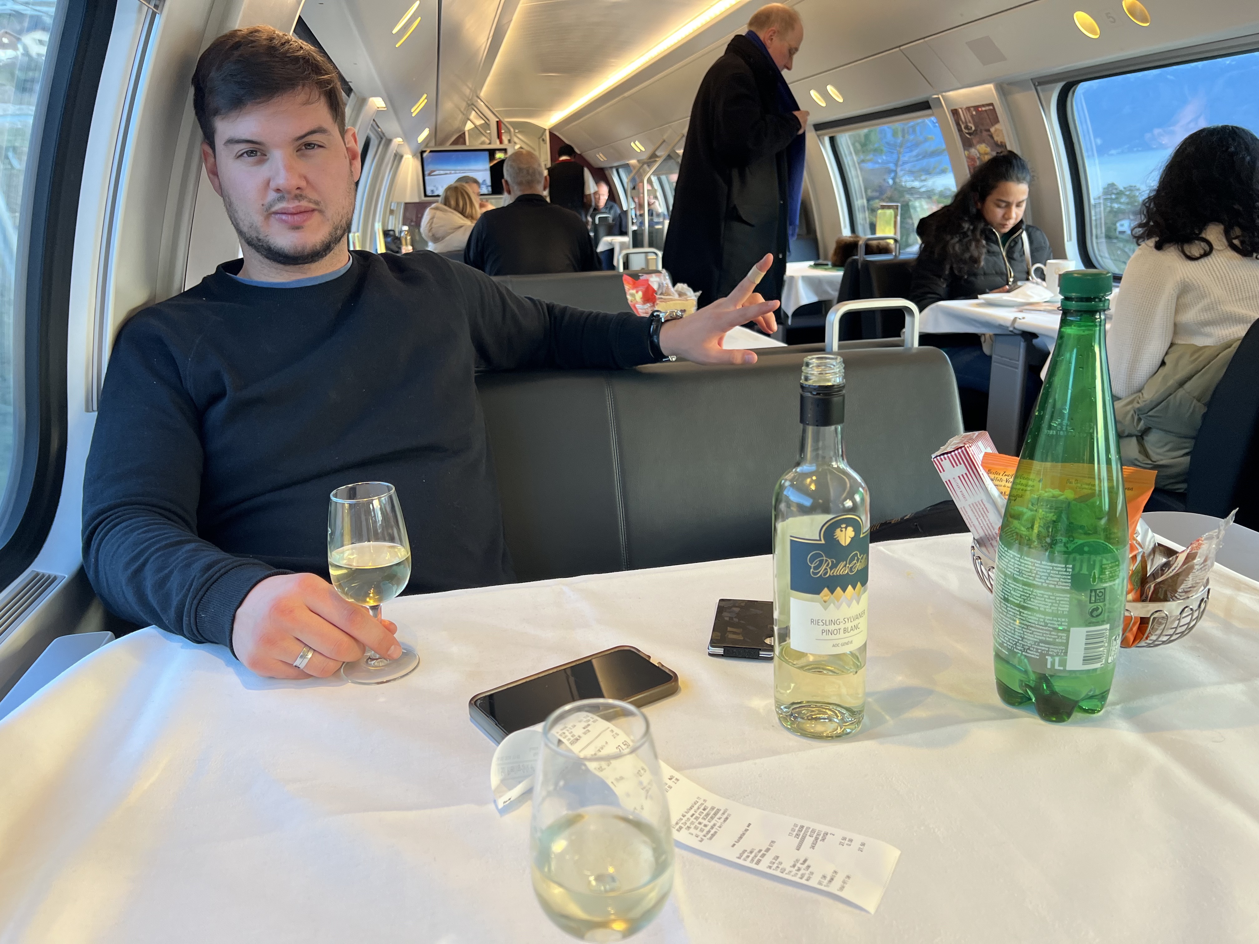 A bottle of white wine and two glasses on the white tablecloth, Swiss restaurant car